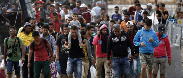 Syrian refugees walk towards Greece's border with Macedonia, moments before crossing near the Greek village of Idomeni