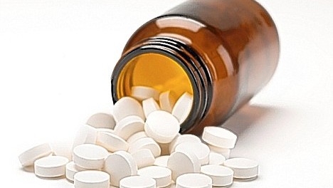 A6P3XM bottle of vitimin C pills spilling out onto a white background vitamin