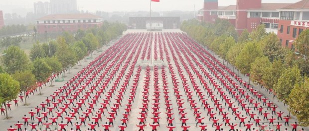 A Chinese national flag flies as students practice Taichi on a playground of a high school, during a Guinness World Record attempt of the largest martial arts display, on a hazy day in Jiaozuo